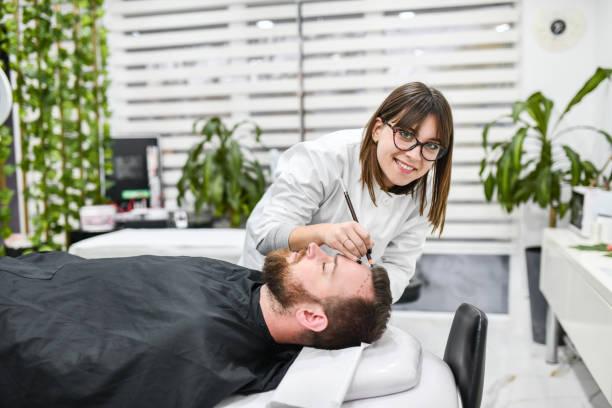 Preparation Of Male Patient For Hair Loss Treatment By Female Doctor In Modern Clinic Preparation Of Male Patient For Hair Loss Treatment By Female Doctor In Modern Clinic hair transplant stock pictures, royalty-free photos & images